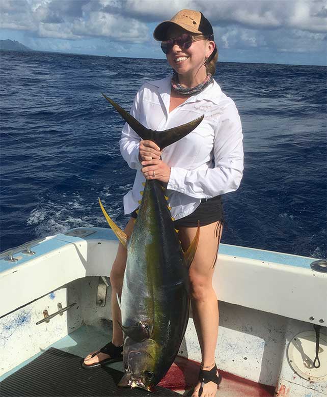 Young woman holding caught yellowfin tuna - Aloha Kauai Sportfishing