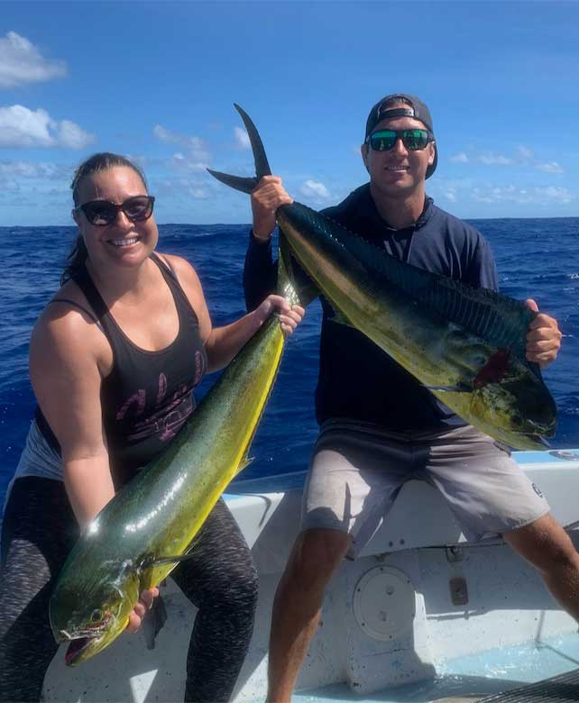 Man an woman holding caught mahi mahi on shared fishing charter - Aloha Kauai Sportfishing